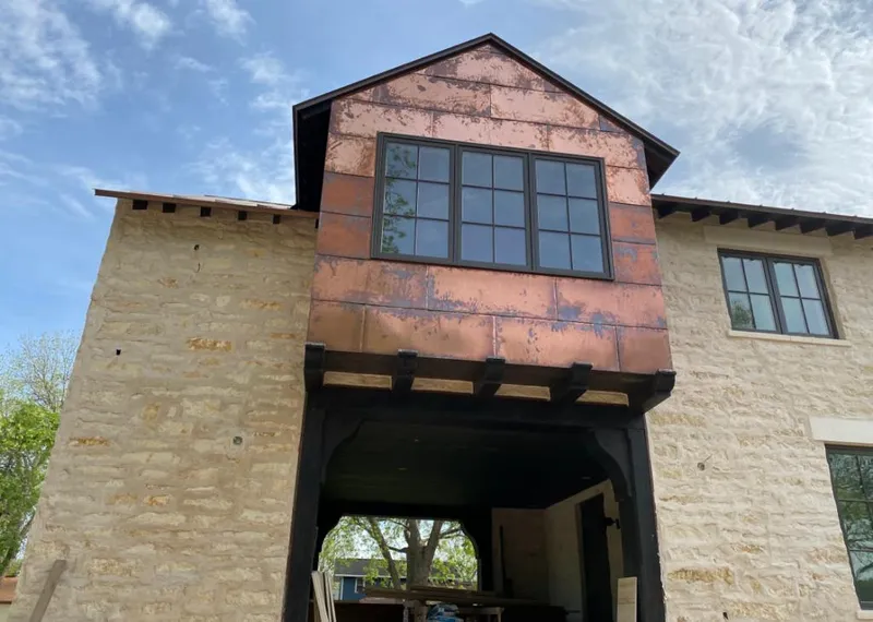 Copper metal panel facade on a stone building for Skylight Installation in Michigan City